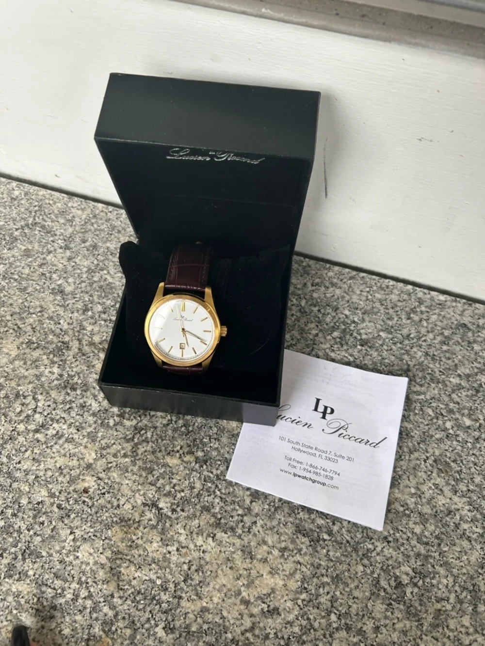 Lucien Piccard Gold Tone Case with Brown Strap and White Dial Accents